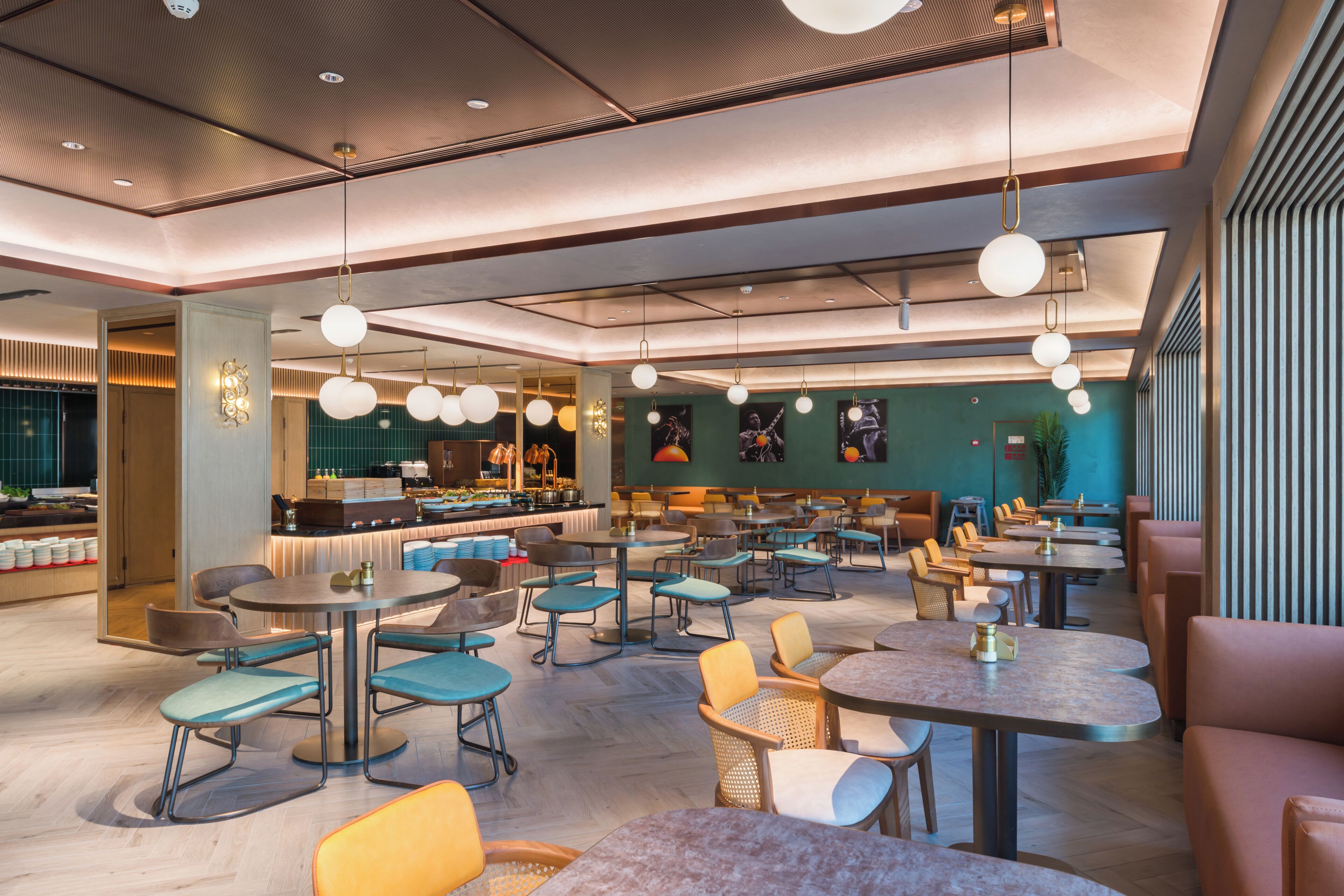 A spacious restaurant with multiple dining tables and chairs, a bar area, and a modern ceiling design.