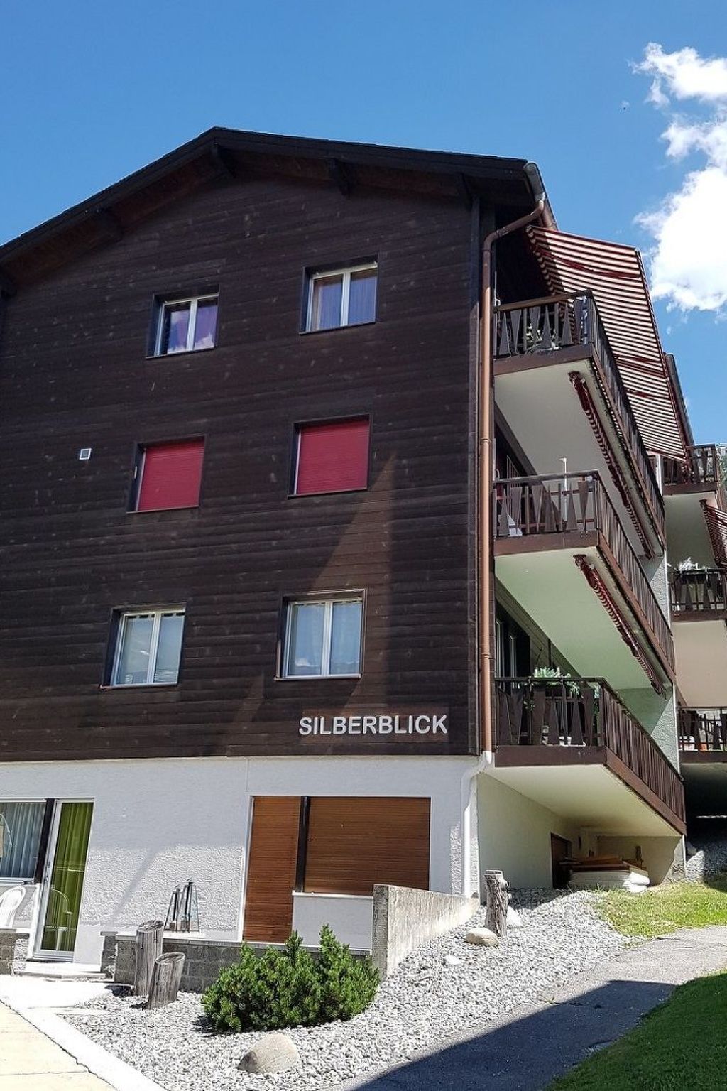En bygning med flere etager, en mørk facade og navnet 'SILBERBLICK' på den nederste etage.