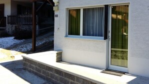 Een gebouw met een witte gevel, een raam met een witte omlijsting, en het nummer '226' op de muur.