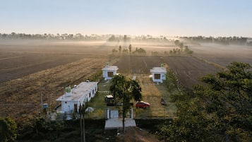 Propiedad rural con varias construcciones, un coche y un barco.