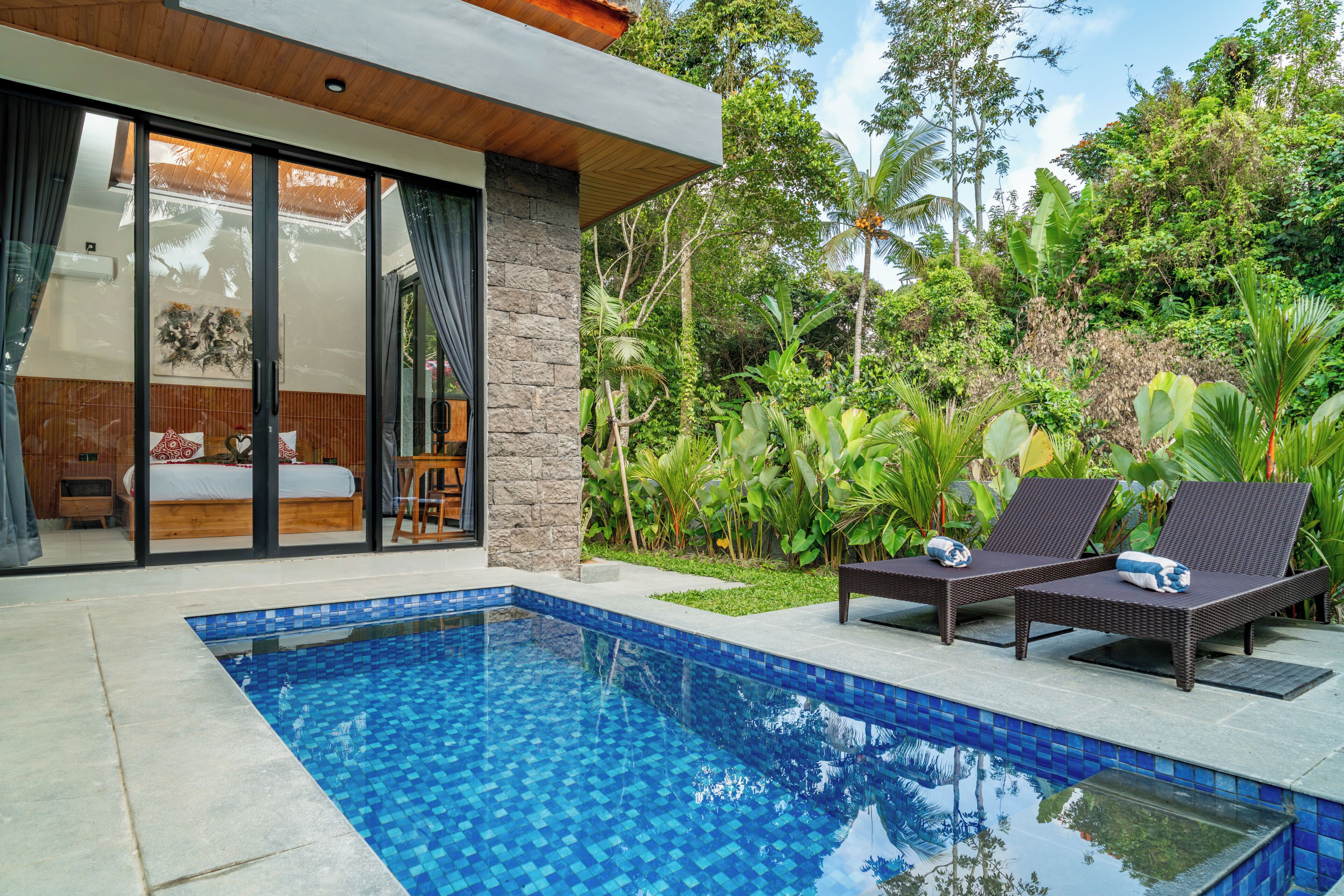 A modern house with a swimming pool, a bedroom with a large window, and a garden with tropical plants.