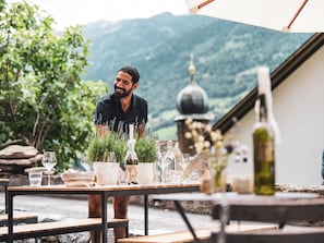 A table set outdoors with wine glasses, bottles, and plants. - Tremondi Boutique BNB & Restaurant, (Quinten), by Interhome (Quinten)