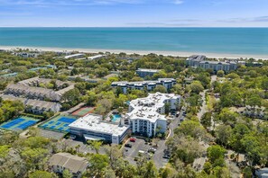 An aerial view of a coastal hotel with multiple buildings, a beach, and tennis courts. - 2BR Villa w/ Bonus Lounge & Wine Fridge, Indoor & Outdoor Pools, Near Coligny (Hilton Head Island)