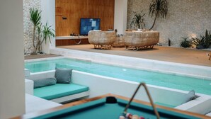 A pool area with a lounge chair and a television in the background. - Casa Cemagi - Luxury 3BR Villa Near Beach by Orivista (Kecamatan Mengwi)