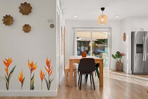 A modern kitchen with a stainless steel refrigerator, wooden dining table, and chairs. - Family-Friendly Seminole Pool Retreat | Fire Pit (Seminole)