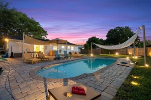 A backyard with a swimming pool, lounge chairs, and a covered patio area. - Family-Friendly Seminole Pool Retreat | Fire Pit (Seminole)