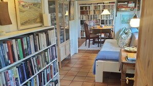 Une pièce confortable avec une bibliothèque, une table à manger et un lit.