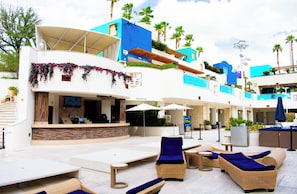 Un resort con mobiliario exterior, piscina y varios niveles de balcones.