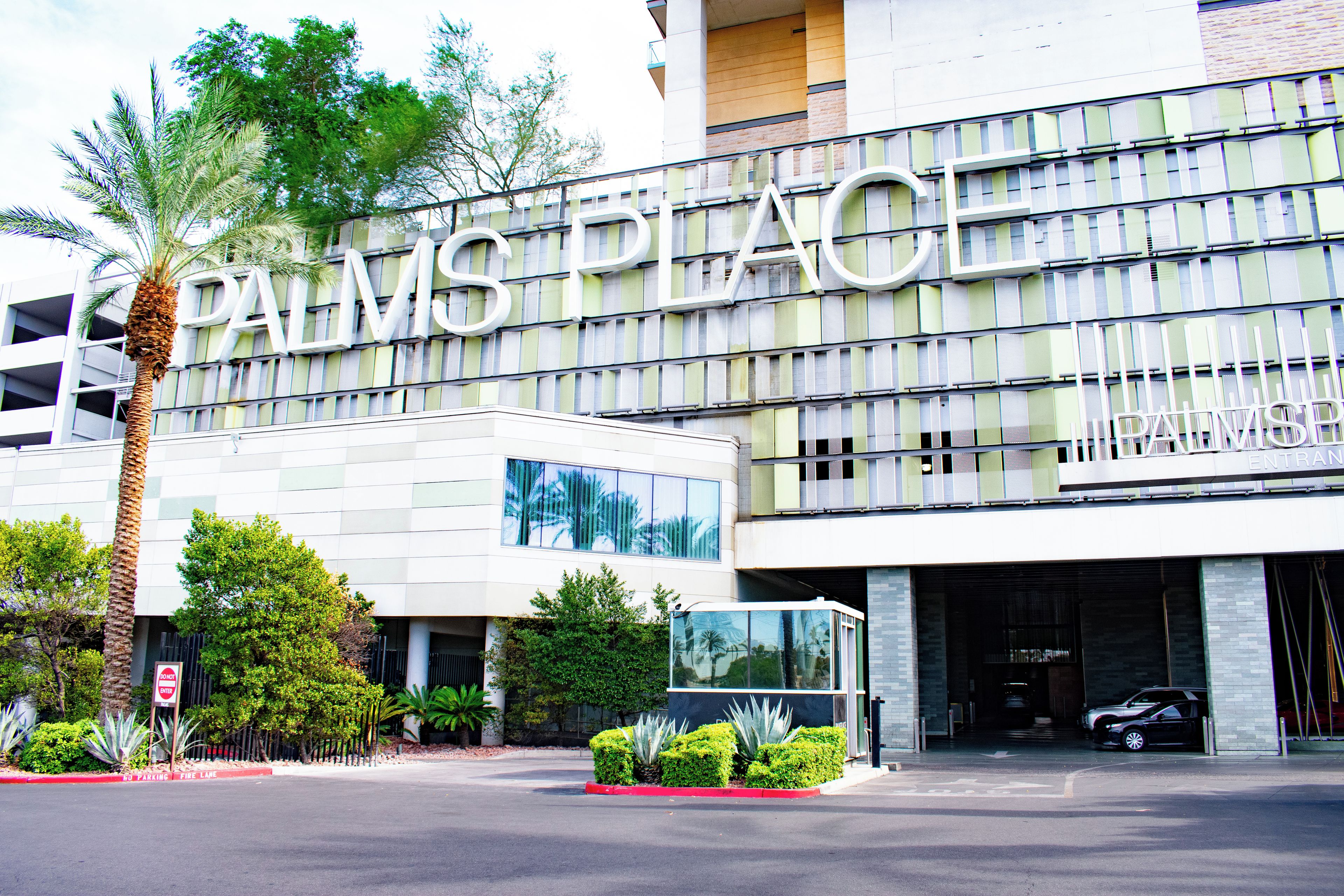 A building with a large sign reading 'PALMS PLACE' and a parking entrance.