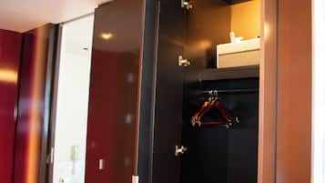 A walk-in closet with a hanging rack and a small shelf.