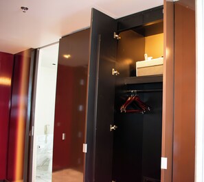 A walk-in closet with a hanging rack and a small shelf. - LasVegas Suite Rental (Las Vegas)