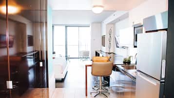 A modern kitchen with a dining area, a large window, and a view of the city.