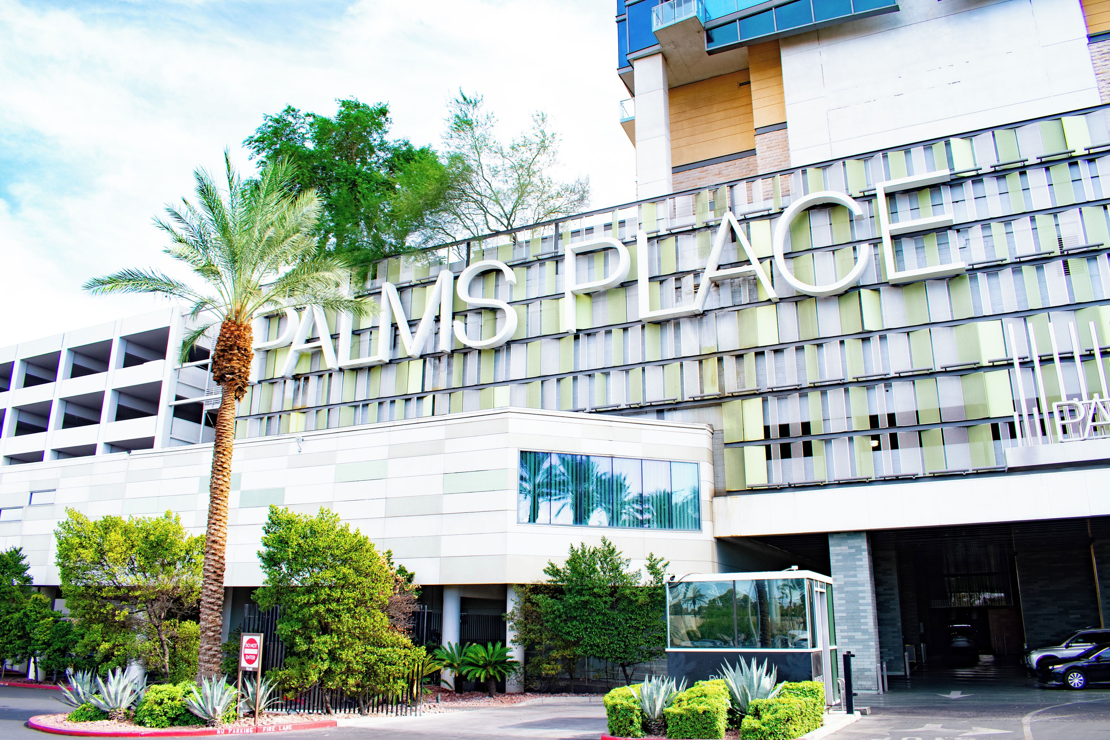 A modern building with a large sign reading 'PALMS PLACE.'