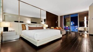 A modern hotel room with a large bed, a sofa, a desk, and a balcony with a city view. - Palms Place Hotel  (Las Vegas)