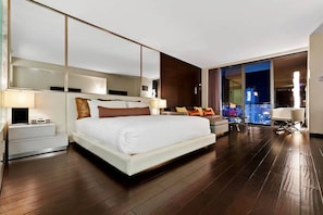 A modern hotel room with a large bed, a sofa, a desk, and a balcony with a city view. - Palms Place Hotel  (Las Vegas)