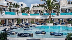 A pool area with lounge chairs and a circular seating area, surrounded by multi-story buildings with balconies and palm trees. - Palms Place Hotel  (Las Vegas)