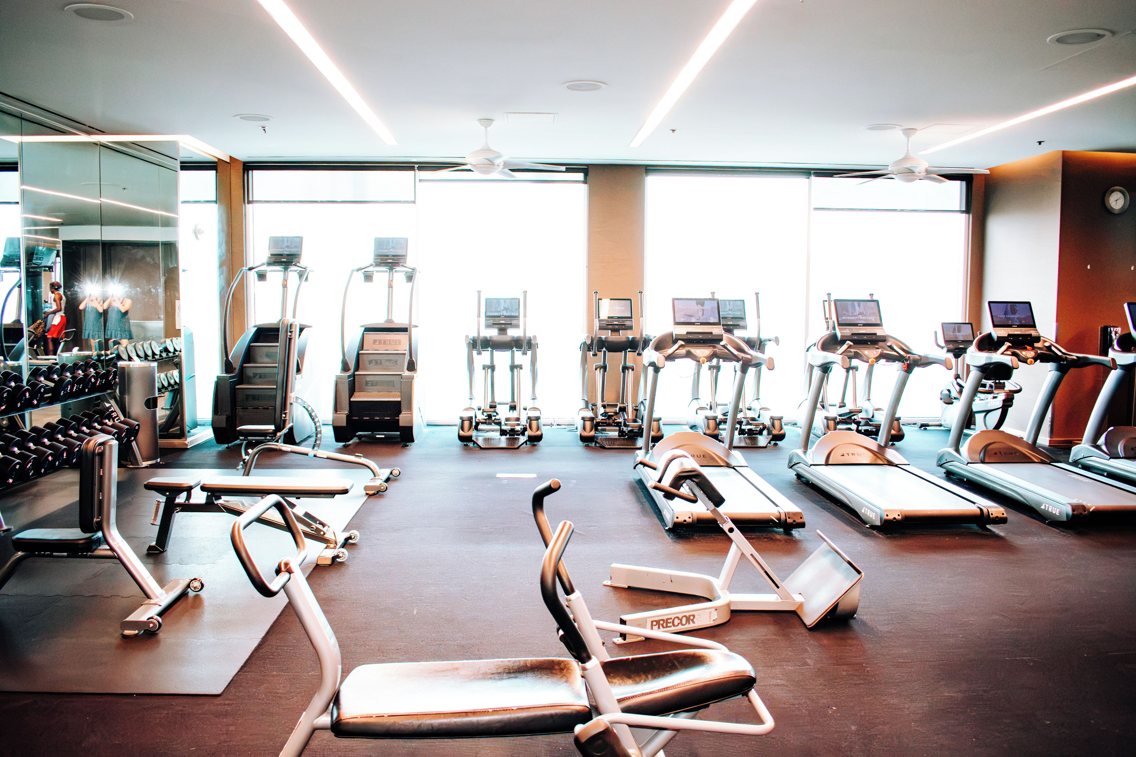 A gym with various exercise equipment, including treadmills, stationary bikes, and weight machines.