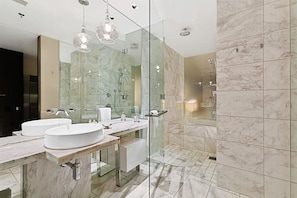 A modern bathroom with two sinks, a glass shower enclosure, and marble flooring. - Palms Place Hotel  (Las Vegas)