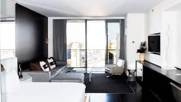 Een moderne hotelkamer met een bed, een bank en een televisie aan de muur.