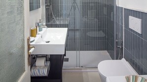 Un bagno moderno con lavandino, specchio e water bianchi.