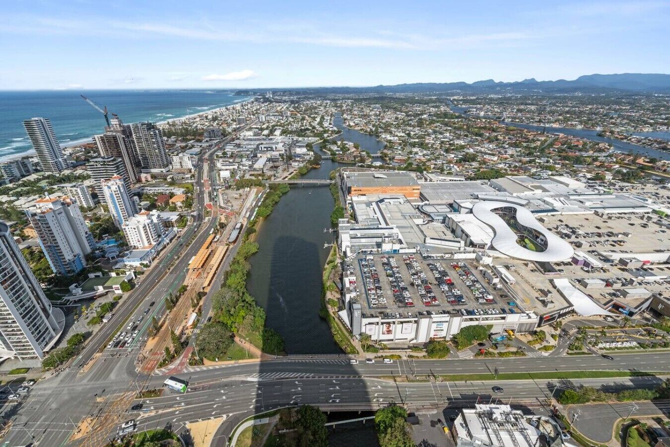Une vue urbaine comprenant une rivière, des immeubles de grande hauteur et un vaste parking.