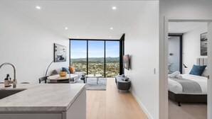 Un appartement moderne comprenant une cuisine, un coin repas et une chambre.