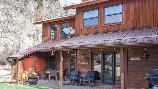 A wooden cabin with a porch, outdoor seating, a grill, and a satellite dish. - Dream Catcher

Dream Catcher (Red River)