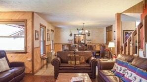 A cozy living room with a brown leather sofa, a wooden coffee table, and a dining area with a wooden table and chairs. - Dream Catcher

Dream Catcher (Red River)