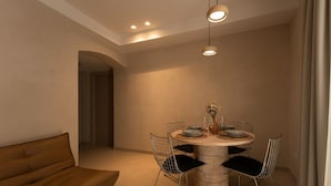 Een moderne eethoek met een ronde tafel, vier stoelen en een bank.