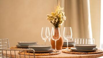 Ein Esszimmertisch mit Geschirr, Gläsern und einer Blumenvase.