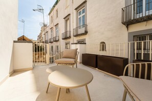 A balcony with a table and chairs, a sofa, and a railing. - Luxe Apartment w/ Panoramic View & Terrace in Heart of Naples (Napoli)