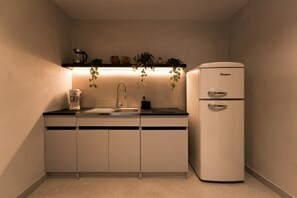A compact kitchen with a sink, a coffee maker, a toaster, and a refrigerator. - Luxe Apartment w/ Panoramic View & Terrace in Heart of Naples (Napoli)