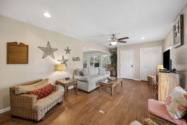 A living room with a sofa, a coffee table, and a television.