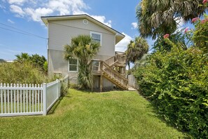 A two-story house with a wooden deck and a white picket fence. - Short Walk to Beach | Pet-Friendly Duplex | Deck & Grill (Fernandina Beach)