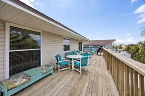 A wooden deck with outdoor furniture, a covered seating area, and a view of neighboring houses. - Short Walk to Beach | Pet-Friendly Duplex | Deck & Grill (Fernandina Beach)