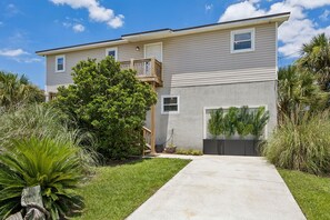 A two-story residential building with a front porch, a small deck, and a well-maintained lawn. - Short Walk to Beach | Pet-Friendly Duplex | Deck & Grill (Fernandina Beach)