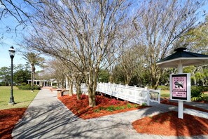 A pathway lined with trees and a white fence, leading to a gazebo. A sign indicates the location is Coastal Georgia, Greenway, St. Mary's Trail. - Downtown St. Marys Retreat | Sleeps 5 (St. Marys)