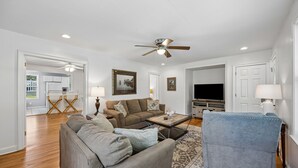 A living room with a ceiling fan, a television, a coffee table, and a sofa. - Downtown St. Marys Retreat | Sleeps 5 (St. Marys)