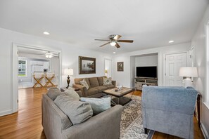 A living room with a ceiling fan, a television, a coffee table, and a sofa. - Downtown St. Marys Retreat | Sleeps 5 (St. Marys)