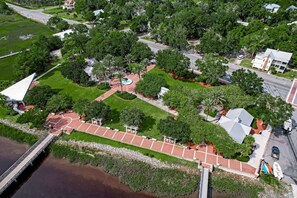 An aerial view of a residential area with a paved walkway, a bridge, and a body of water. - Downtown St. Marys Retreat | Sleeps 2 (St. Marys)