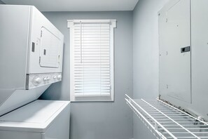 A laundry room with a washing machine, a dryer, and a metal drying rack. - Silver Beach 801 | Beachfront & Dog-Friendly | Top Floor Corner Condo (Orange Beach)