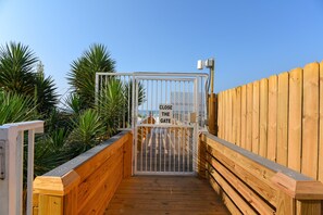 A wooden boardwalk leading to a gated entrance with a 'CLOSE THE GATE' sign. - The Enclave 801 | Gulf Front Corner Condo | Wraparound Balcony | My Beach Getaways (Orange Beach)