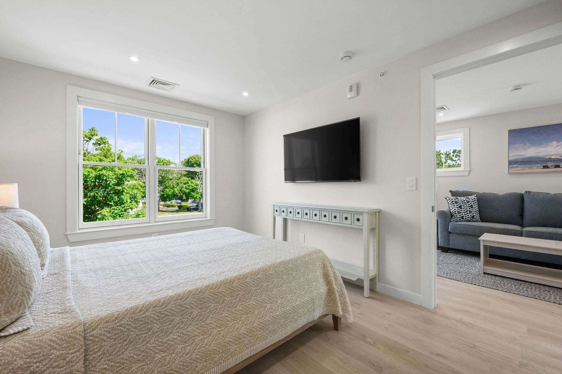 Une chambre à coucher avec un lit, une télévision et une fenêtre donnant sur un paysage verdoyant.