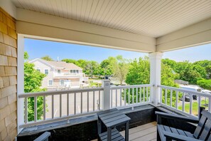 Eine überdachte Veranda mit Blick auf ein Haus und Bäume.