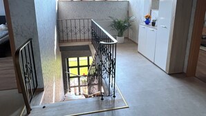 Ein modernes Interieur mit einer Treppe, einer Küchenzeile und Blick ins Freie.