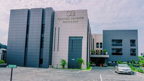 Un edificio moderno con un letrero que dice 'GRANDE CANDOR Exclusive Hotel'.