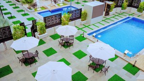 Zona junto a la piscina con diversas opciones de asientos y una piscina.