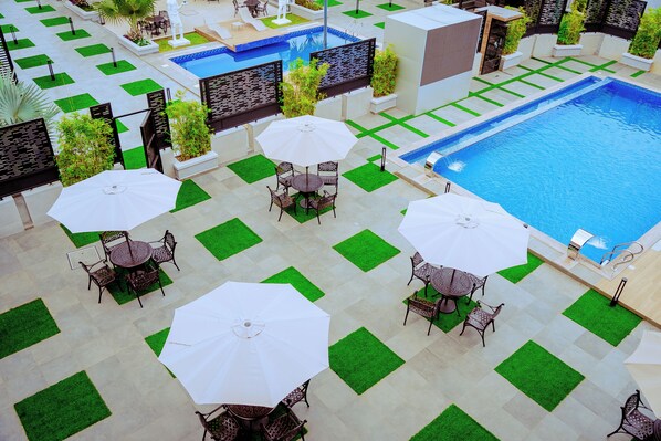 Zona junto a la piscina con diversas opciones de asientos y una piscina.