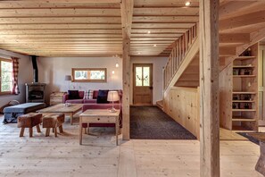 Ein Holzinnenraum mit einer Couch, einem Couchtisch und einer Treppe.
