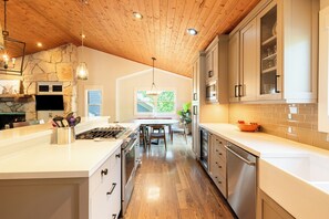 A modern kitchen with wooden ceiling, white cabinetry, and a central island. - 5BR Park City retreat with hot tub, fireplace, mountain views. (Park City)